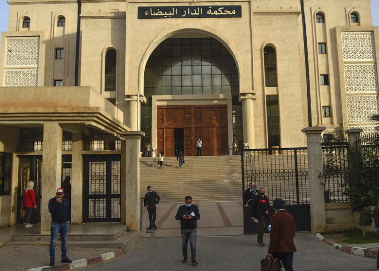 People gather in front of the  Algerian Dar Al-Baida tribunal in the capital Algiers, where the trial of men accused of the murder of Herve Gourdel, a French mountain guide who was decapitated by jihadists almost six years ago is taking place, on February 4, 2021. - Fourteen people are being prosecuted: 8 suspected kidnappers, the 5 Algerian hosts and companions of the Frenchman, as well as a man, Farjallah Amara, whose link to this case is not specified, according to a court document consulted by AFP. (Photo by RYAD KRAMDI / AFP)